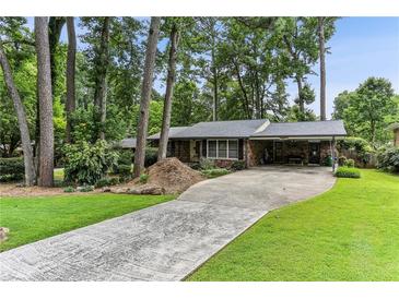 Charming brick home with a long driveway, a carport, and a well-manicured lawn at 1263 Blueberry Trl, Decatur, GA 30033