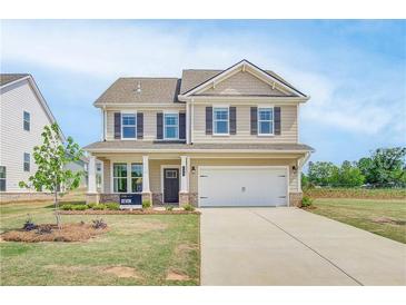 Charming two-story home with neutral siding, inviting front porch, and a two-car garage at 568 Teversham Dr, Mcdonough, GA 30253