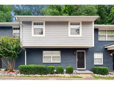 Inviting two-story townhome with a beautifully painted brick facade and lush landscaping at 3149 Buford Ne Hwy # 2, Atlanta, GA 30329
