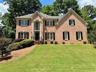 Beautiful two-story brick home with manicured lawn and mature trees at 851 Millvale Pl, Lawrenceville, GA 30044