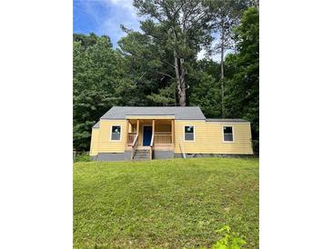 Charming yellow bungalow with a lovely front yard and a welcoming porch area at 451 Collier Ridge Nw Dr, Atlanta, GA 30318