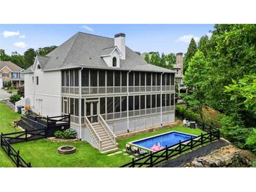 Expansive backyard with a screened porch, swimming pool, and a neatly fenced garden area offers serene outdoor living at 6017 Chestatee Creek Nw Ct, Acworth, GA 30101