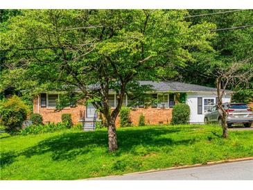 Charming single-story brick home featuring a lush, green lawn and mature trees for added privacy and curb appeal at 379 Utoy Sw Cir, Atlanta, GA 30331