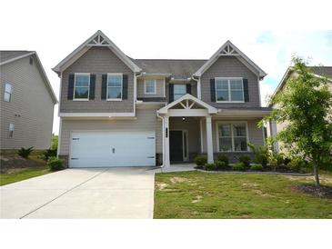 Charming two-story home with a well-manicured lawn and a two-car garage at 7753 Hansel Ln, Lithonia, GA 30058