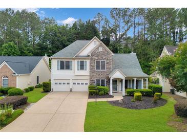 Charming two-story home with a two-car garage, stone accents, and a well-manicured lawn at 4206 Moccasin Trl, Woodstock, GA 30189