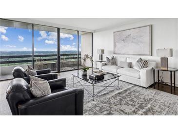 Bright living room featuring large windows, a balcony, and a comfortable seating area with modern decor at 2660 Peachtree Nw Rd # 23A, Atlanta, GA 30305