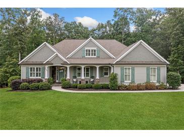 Charming single-story home featuring a manicured lawn and a welcoming front porch with rocking chairs at 208 Wilshire Ter, White, GA 30184