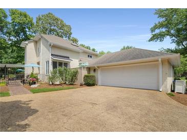 Charming home exterior with a two-car garage, landscaped yard, and a cozy outdoor seating area at 2610 Links End, Roswell, GA 30076