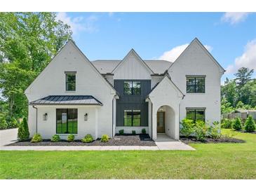 Stunning two-story white brick home with black-framed windows and manicured lawn at 103 Maddox Rd, Buford, GA 30518