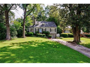 Charming home featuring manicured front lawn, beautiful landscaping, and inviting blue front door at 2811 Alpine Ne Rd, Atlanta, GA 30305