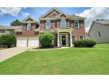 Charming two-story brick home featuring a well-manicured lawn and a two-car garage at 412 Middlebrooke St, Canton, GA 30115