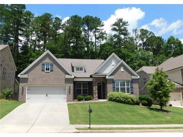 Charming brick home with manicured lawn and two-car garage in a lush, green setting at 330 La Perla Dr, Sugar Hill, GA 30518