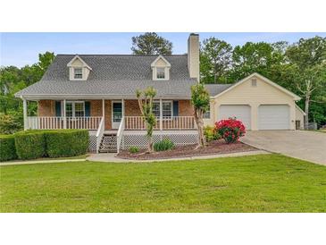 Charming two-story home with brick and siding, a covered porch, a two-car garage, and a well-maintained front yard at 1320 Pinyon Pl, Lawrenceville, GA 30043