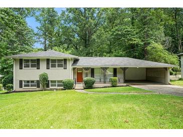 Charming split-level home with brick facade, manicured lawn, and covered carport nestled in lush greenery at 1534 Sw Austin Sw Rd, Atlanta, GA 30331