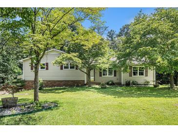 Charming home featuring a well-maintained lawn, mature trees, and a classic exterior at 2067 Skyhawk Ln, Acworth, GA 30102