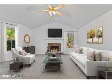 Bright living room features vaulted ceilings, fireplace, and neutral decor, creating an inviting atmosphere at 305 Bridgewater Ter, Canton, GA 30115