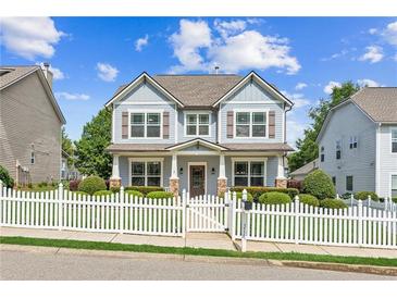 Charming two-story home featuring a white picket fence, landscaped yard, and inviting front porch at 3725 Downing Dr, Cumming, GA 30040