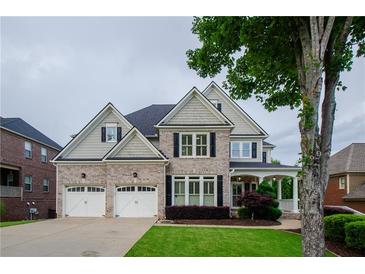 Stately brick home featuring a manicured lawn and a two-car garage at 4645 Wykeshire Ct, Cumming, GA 30041