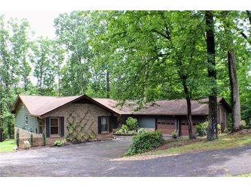 Charming single-story brick home with a well-maintained lawn, mature trees, and an attached two-car garage at 1310 Larkview Sw Dr, Lilburn, GA 30047