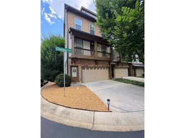 Beautiful townhome featuring a charming balcony, stone accents, and a well-maintained lawn on a sunny day at 3235 Chutney Ct, Avondale Estates, GA 30002