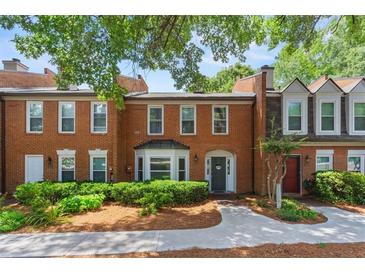 Charming brick townhome with manicured landscaping, providing a welcoming and picturesque curb appeal at 4113 Ashford Green Dr, Duluth, GA 30096