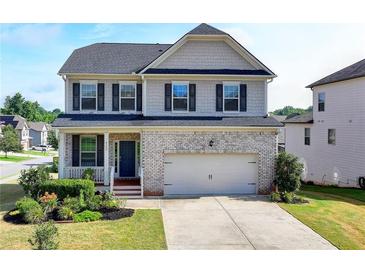 Charming two-story home with a brick facade, covered porch, and well-manicured landscaping at 4250 Pembia Dr, Cumming, GA 30028