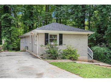 Ranch-style home surrounded by lush trees and features grey brick at 2721 Glenvalley Dr, Decatur, GA 30032