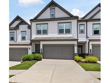 Charming townhome featuring a two-car garage and well-maintained landscaping at 320 Crider Ct, Woodstock, GA 30188