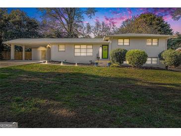 Charming brick home with a well-manicured lawn and covered parking area at 1151 Bromley Rd, Avondale Estates, GA 30002