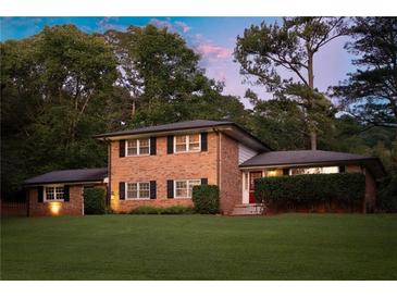 Beautiful two-story brick home with manicured lawn and mature trees providing shade and privacy at 1392 Cornwall Rd, Decatur, GA 30032