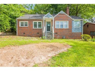 Charming brick home with a cozy front porch and spacious front yard perfect for outdoor activities at 879 Sylvan Sw Pl, Atlanta, GA 30310