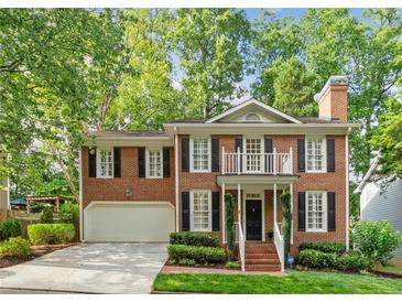 Charming brick home featuring black shutters, lush landscaping and an attached two car garage at 1117 Haven Glen Ne Ln, Brookhaven, GA 30319
