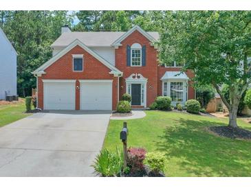 Charming two-story brick home featuring a manicured lawn and a two-car garage at 508 Keeneland Ave, Woodstock, GA 30189