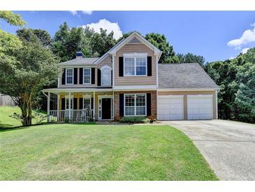 Charming two-story home with a manicured lawn, inviting front porch, and two-car garage at 5385 Spotted Fawn Ct, Suwanee, GA 30024