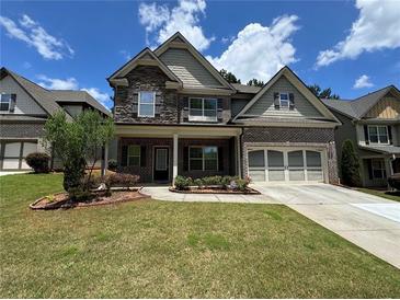 Charming two-story home features brick and stone accents, a two-car garage, and a well-maintained front yard at 3270 Arbor Oaks Dr, Snellville, GA 30039