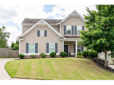 Charming two-story home featuring manicured lawn and stone-accented landscaping at 207 Cross Rd, Acworth, GA 30102