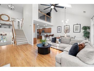 Bright living room with hardwood floors, high ceilings, and a large comfortable sectional sofa at 6403 Queens Court Trce, Mableton, GA 30126