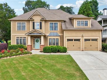 Charming two-story home featuring a manicured lawn, beautiful landscaping, and a welcoming front entrance at 3595 Millwater Xing, Dacula, GA 30019