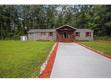 Charming brick home featuring a covered front porch, freshly painted driveway, and a well-maintained lawn at 4670 Brookwood Dr, Cumming, GA 30041