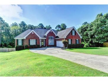 Charming single-story brick home with a well-manicured lawn and a long driveway leading to an attached garage at 2068 Tribble View Way, Lawrenceville, GA 30045