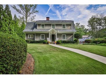 Charming two-story home with landscaped yard, walkway, and inviting front porch with rocking chairs at 1658 E Clifton Ne Rd, Atlanta, GA 30307
