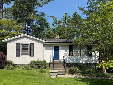 Charming one-story home with brick accents, manicured lawn and mature trees providing shade at 881 Mclinden Se Ave, Smyrna, GA 30080