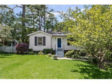 Charming home features a well-manicured lawn and inviting curb appeal with fresh landscaping at 881 Mclinden Se Ave, Smyrna, GA 30080