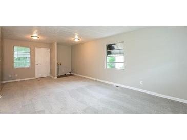 Bright living room featuring neutral paint, carpeted floor, and natural light from the windows at 1079 Stonewall Drive Southeast, Atlanta, GA 30315