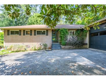 Charming brick home featuring a well-maintained yard and attached garage at 3300 Wiltshire Dr, Avondale Estates, GA 30002
