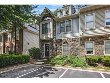 Charming townhome with stone and siding exterior, lush landscaping, and convenient parking at 1244 Harris Commons Pl, Roswell, GA 30076