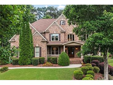 Beautiful two-story brick home featuring a manicured lawn and mature landscaping at 2845 Aquitania Ln, Cumming, GA 30040