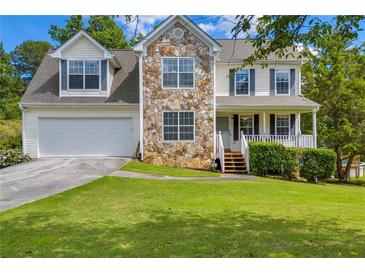 Charming two-story home featuring stone accents, a well-manicured lawn, and an attached two-car garage at 684 Doe Lane Ln, Loganville, GA 30052