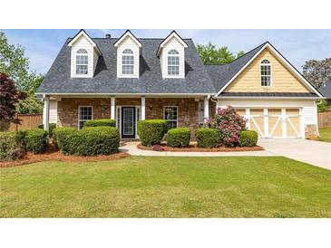 Charming, two-story home boasts stone accents, a well-manicured lawn, and a cozy, inviting front porch at 3012 Keeneland Blvd, Mcdonough, GA 30252