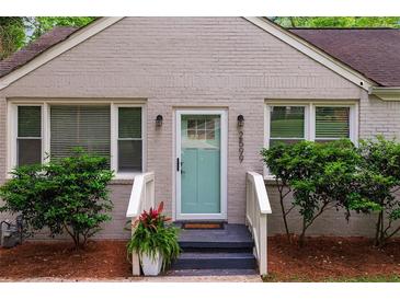 Charming front door with light-blue paint and decorative sidelights, framed by landscaped bushes and dark-painted porch at 2599 E Tupelo Se St, Atlanta, GA 30317